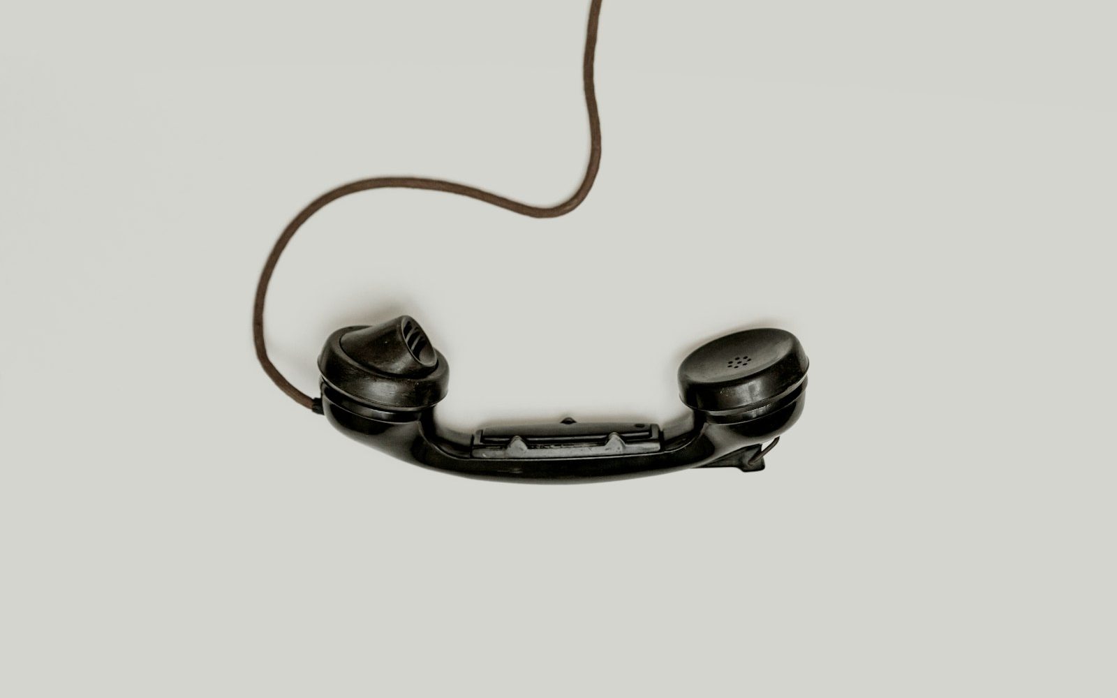 Vintage telephone handset hanging by its cord, the old answering service model AI pricing replaced