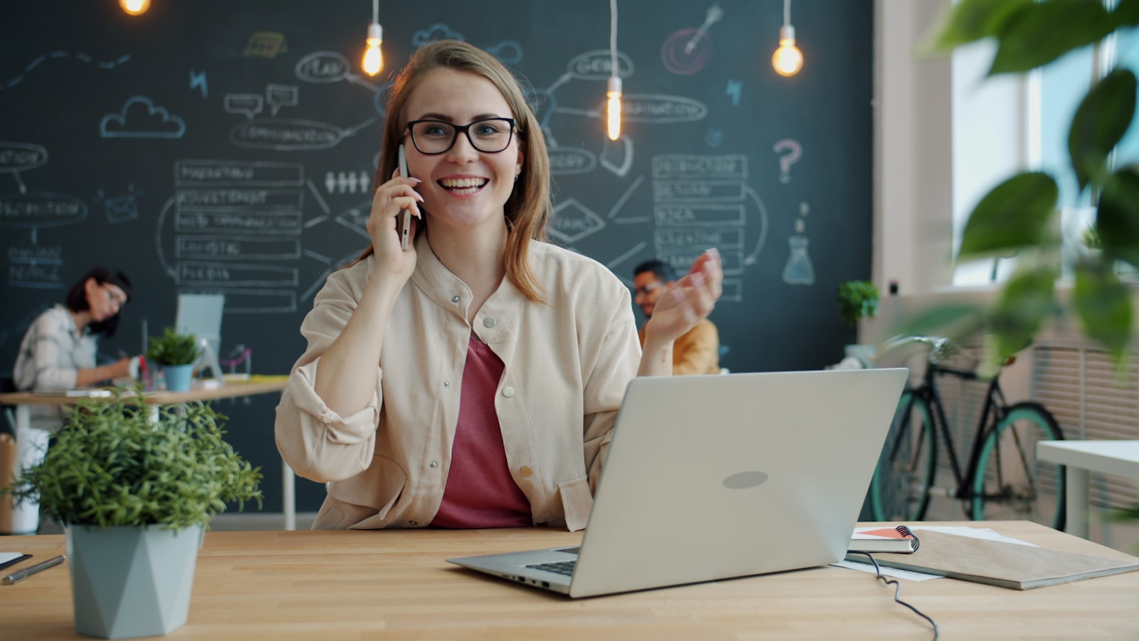 The complete small business phone system guide Small business owner talking on the phone in a modern office