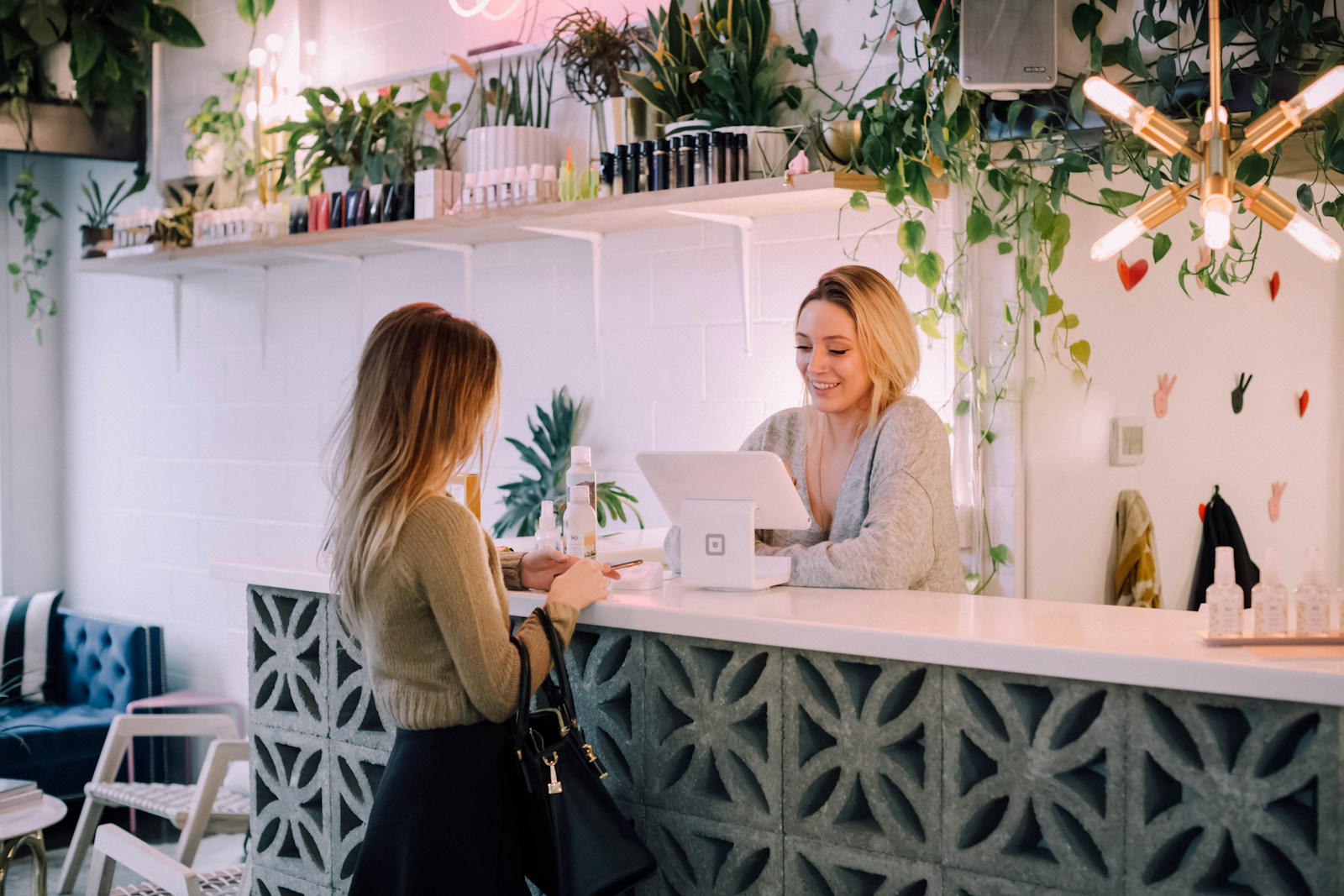Virtual receptionist vs human receptionist comparison Receptionist standing at a front desk counter greeting visitors